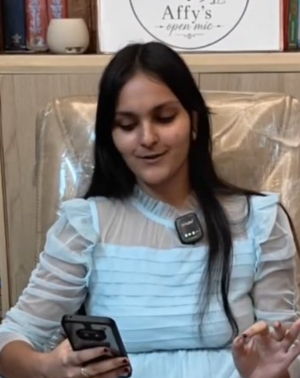 A poet reading from her phone at Affy's Open Mic